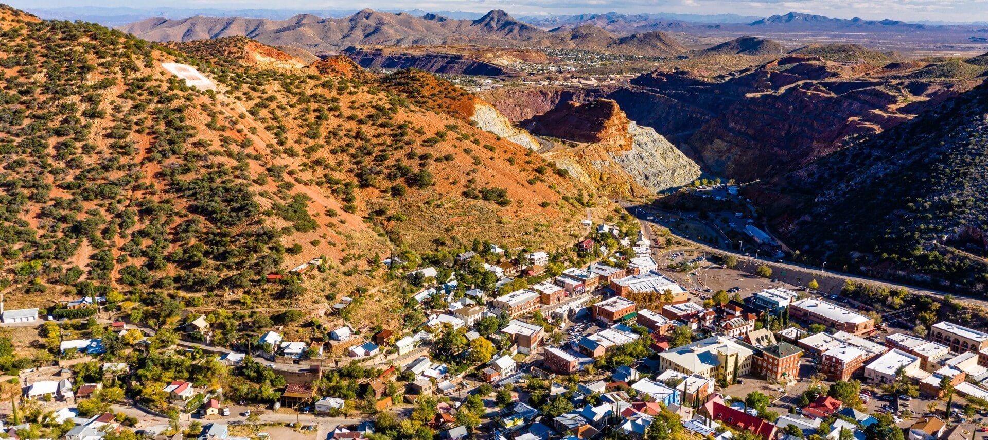 Drone view of an expansive arrid valley with mountains and a small town tucked below